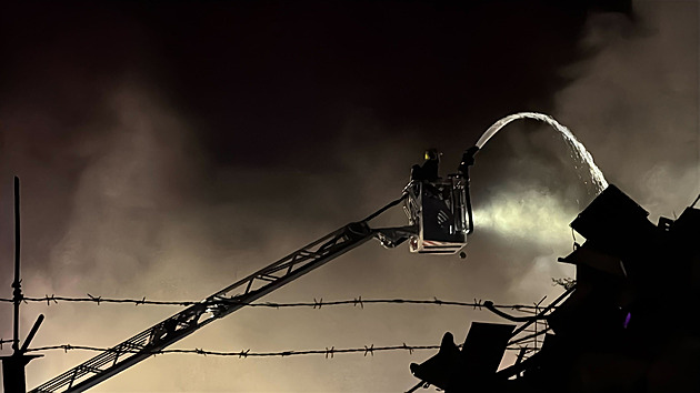 Noční požár v Hostivaři. Hořel elektroodpad a šrot, hasiči použili speciální techniku